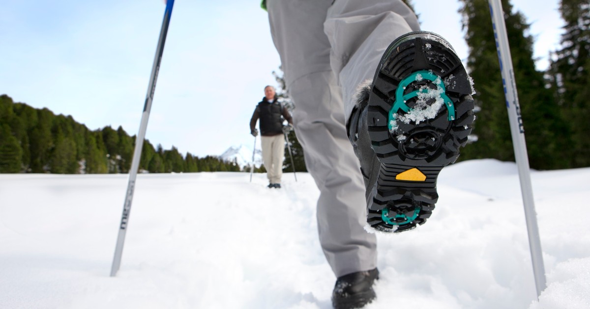 Ice spike attachments on winter boots walking on wet icy pavement